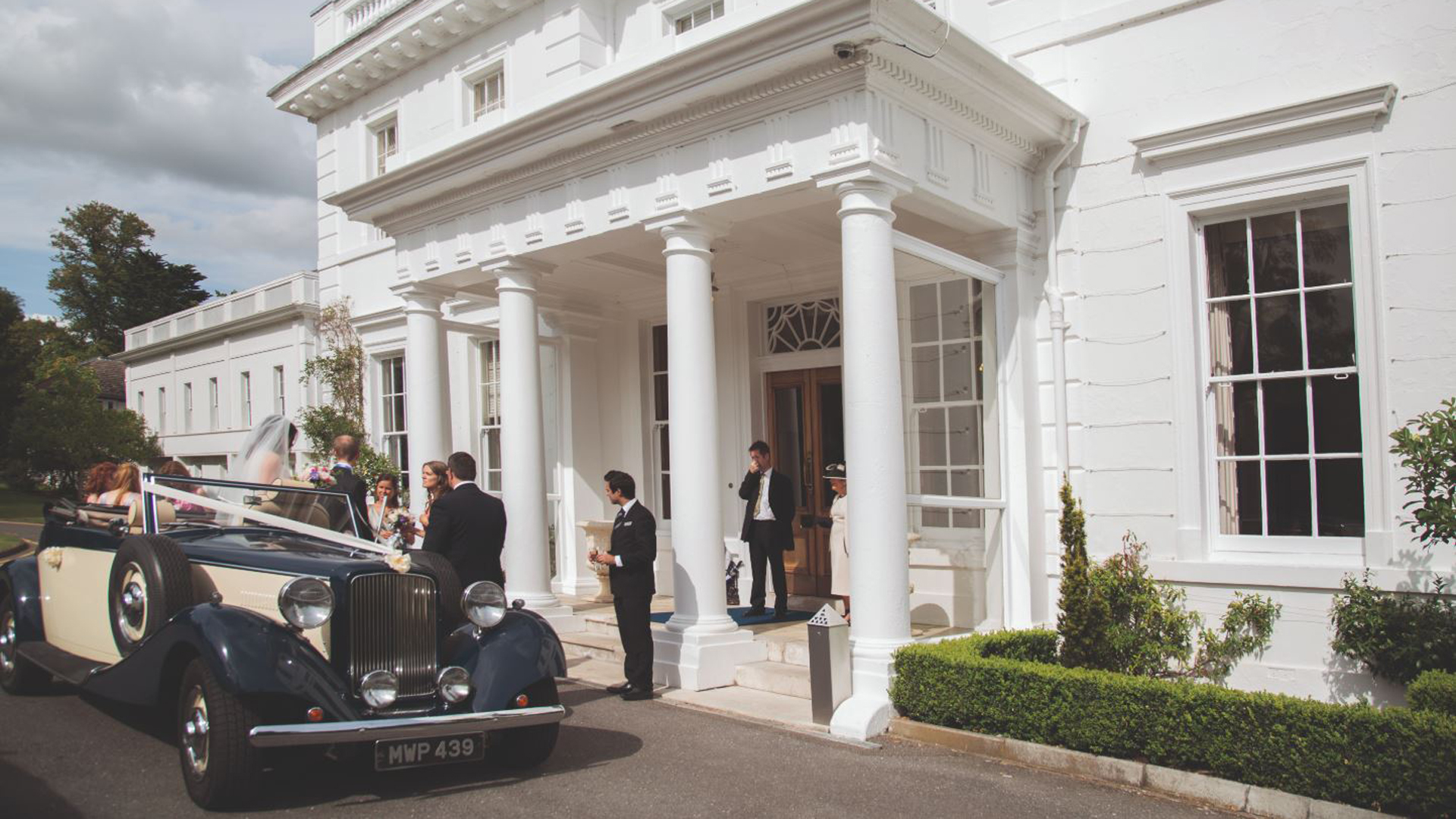 A photo outside henley reception building with wedding car