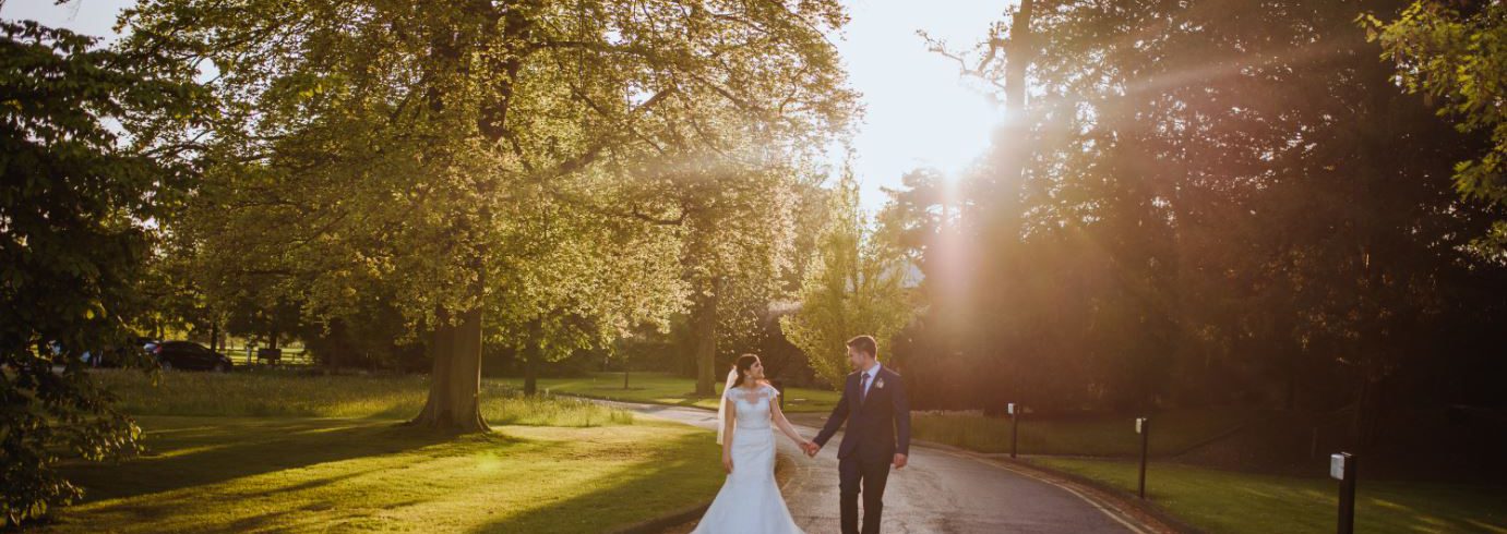 A wedding photo of a couple walking along the main pathway