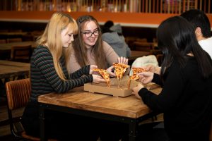 A photo of students eating pizza at Park Bar