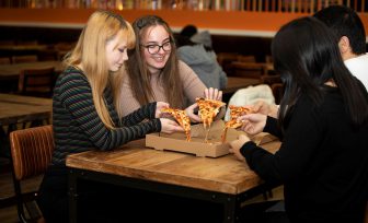 A photo of students eating pizza at Park Bar