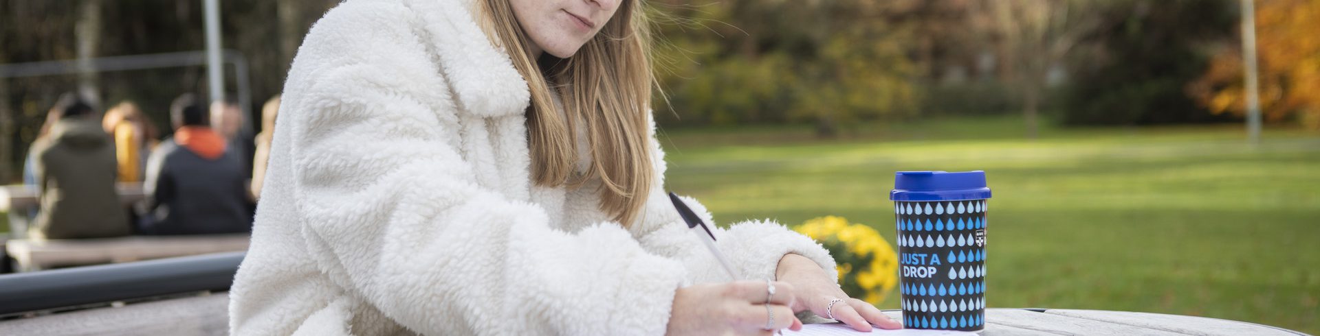 A photo of a student with a reusable coffee cup