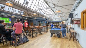 Photograph of the Dairy showing students playing pool and eating food