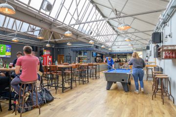 Photograph of the Dairy showing students playing pool and eating food